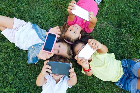 Portrait of group of childrens taking a selfie in the park.の写真素材