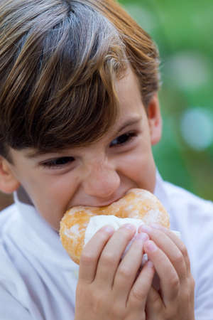 Portrait of boy eating in the park.の写真素材