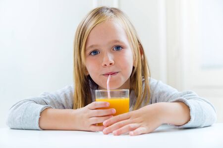 Portrait of beautiful child having breakfast at home.の写真素材