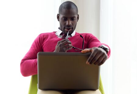 Portrait of handsome young man working with his laptop at home.