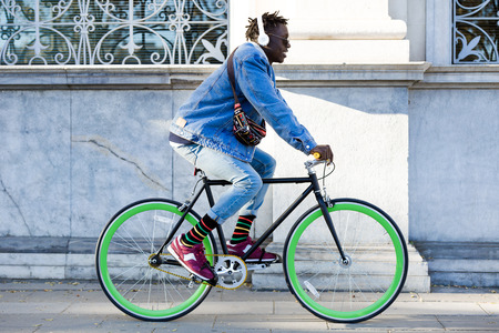 Portrait of handsome young man riding bike in the street.の写真素材