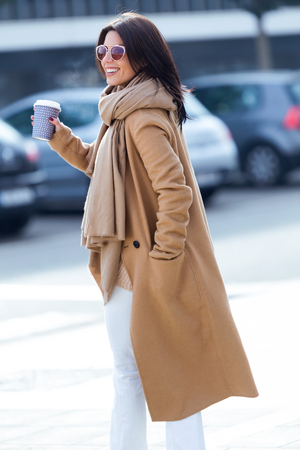 Portrait of beautiful young woman using her mobile phone in the street.の写真素材
