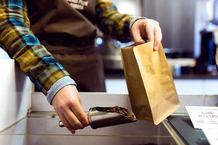 Close-up of a saleswoman selling bulk coffee at an organic store.の写真素材