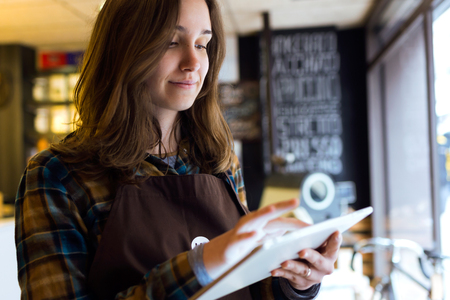 Portrait of beautiful young saleswoman using her digital tablet in organic shop.の写真素材