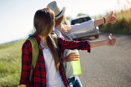 Portrait of two beautiful ladies hikers walking on the road.の写真素材