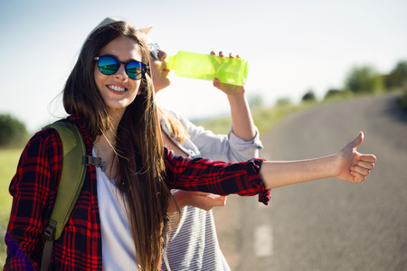 Portrait of two beautiful ladies hikers walking on the road.の写真素材