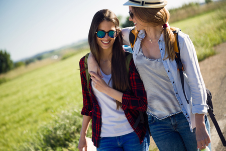 Portrait of two beautiful ladies hikers walking on the road.の写真素材