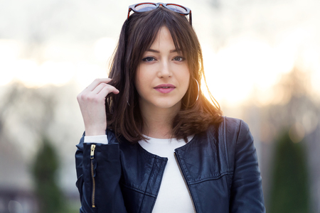 Portrait of beautiful young woman looking at camera in the street.の写真素材