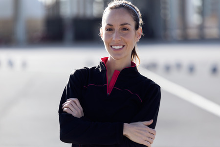 Portrait of fit and sporty young woman looking at camera in the park.の写真素材