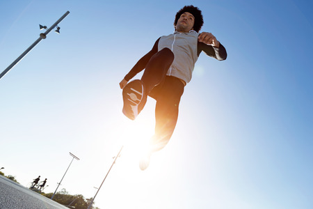 Portrait of fit and sporty young man running in the city.