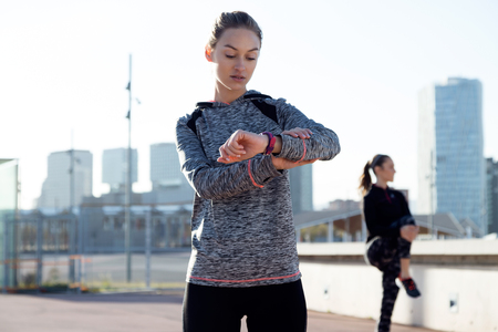Portrait of two fit and sporty young women relaxing after work out in the park.の写真素材