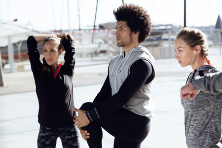 Portrait of fit and sporty team stretching in the city.の写真素材