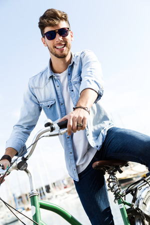 Portrait of handsome young man cycling in the city.の写真素材