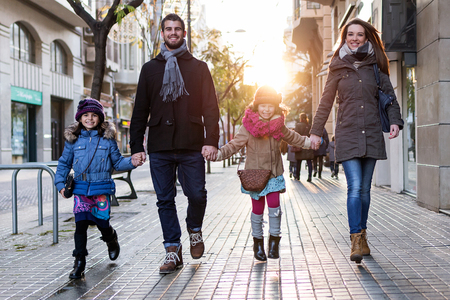 Portrait of happy young family having fun in the street.の写真素材