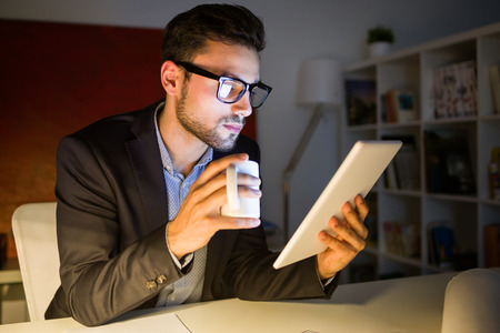 Portrait of handsome young man working with digital tablet in the office.の写真素材