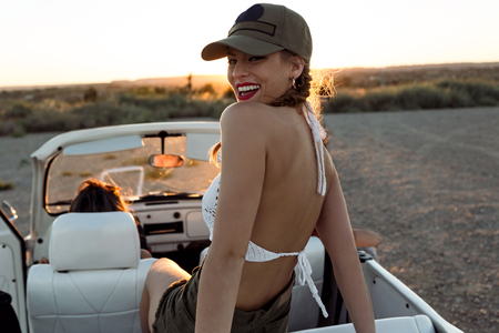 Portrait of pretty young woman driving on road trip on beautiful summer day.の写真素材