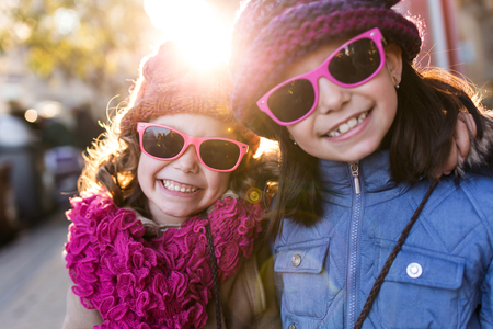 Portrait of two llittle sisters having fun in the street.の写真素材