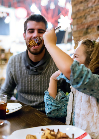Portrait of happy young family having breakfast in the cafe.の写真素材