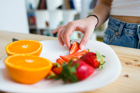 Portrait of beautiful young woman enjoying breakfast at home.の写真素材