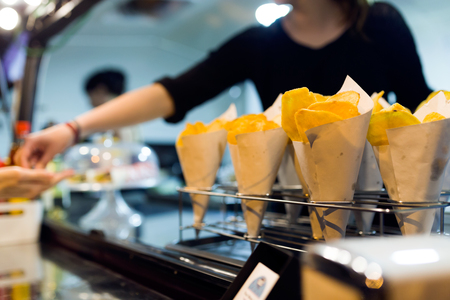 Close-up of young woman serving to a costumer in a food truck.の写真素材