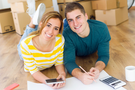Portrait of young couple with digital tablet in their new home