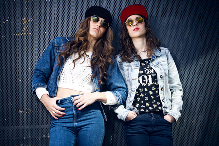 Portrait of a young beautiful girls with denim suit in a urban background