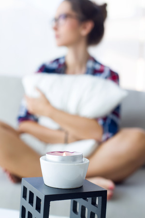 Portrait of beautiful young woman relaxing on sofa at home.の写真素材