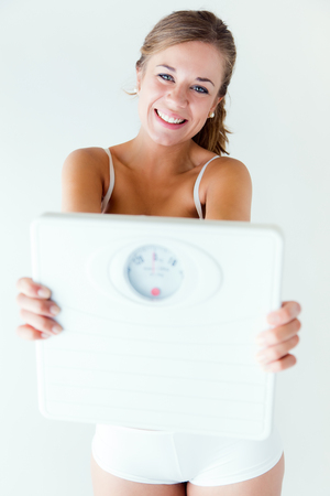 Portrait of young girl in underwear holding scale.の写真素材