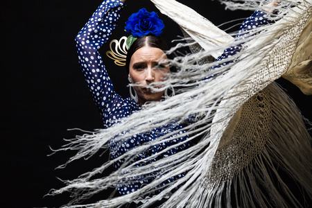 Portrait of young flamenco dancer in beautiful dress on black background.の写真素材