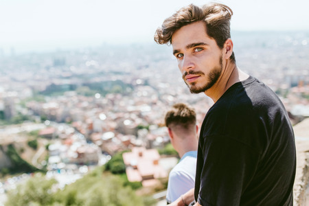 Portrait of two young men looking at the views form the top of a mountain.の写真素材