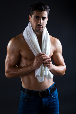 Portrait of beautiful and muscular man in dark background.の写真素材