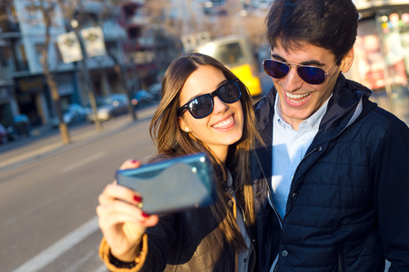 Portrait of happy young couple taking selfies with smartphone.