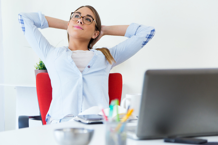 Portrait of pretty young woman relaxing one moment in her office.の写真素材