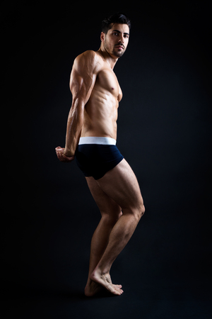 Portrait of beautiful and muscular man in dark background.の写真素材