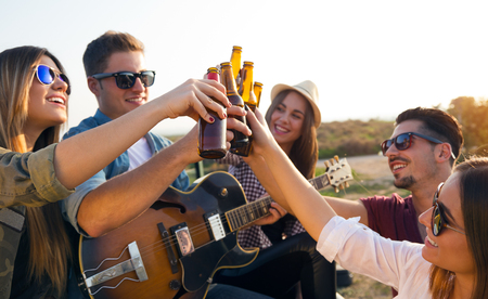 Outdoor portrait of group of friends toasting with bottles of beer.の写真素材