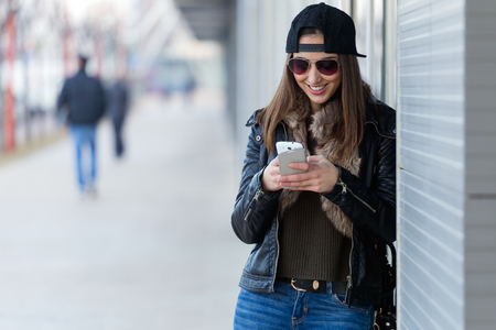 Outdoor portrait of young beautiful woman with mobile phone.の写真素材