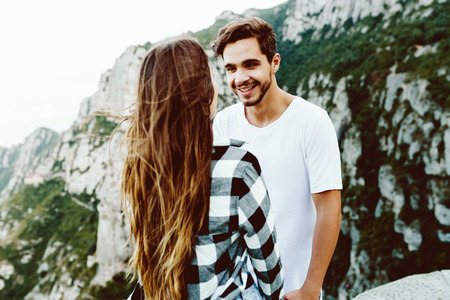 Portrait of beautiful young couple enjoying nature at mountain peak.の写真素材