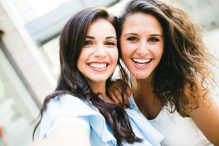 Portrait of beautiful young women looking at camera in the street.の写真素材