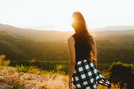 Portrait of beautiful young woman enjoying nature at mountain peak.の写真素材