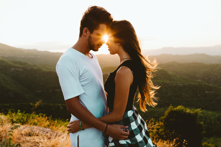 Portrait of beautiful young couple enjoying nature at mountain peak.の写真素材