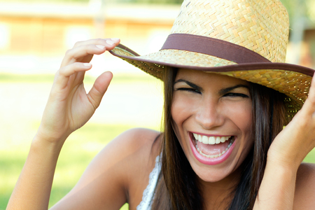 Portrait shot of a beautiful woman with hat in a parkの写真素材