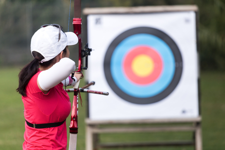Portrait of female athlete practicing archery in stadium.の写真素材