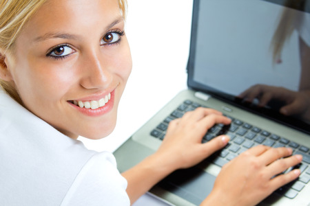 Beautiful young woman with laptop in studioの写真素材