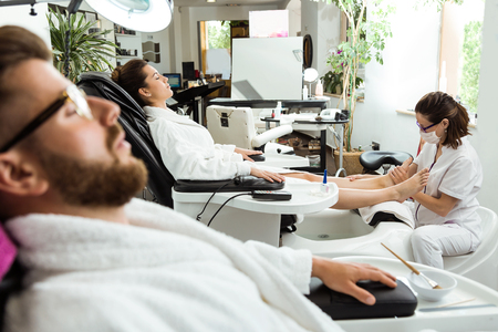 Portrait of young woman doing pedicure in salon. Beauty concept.の写真素材
