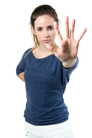 Portrait of young woman making stop sign in front of the cameraの写真素材