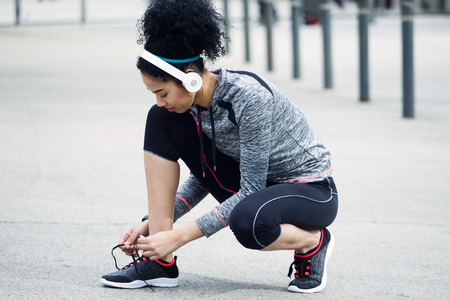 Portrait of fit and sporty young woman tying her laces before a run.の写真素材