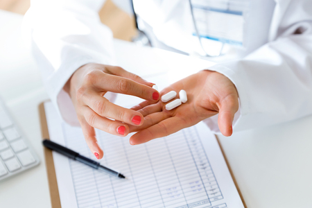 Portrait of female doctor giving you a pill.の写真素材