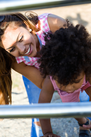 Portrait of beautiful young mother with her son having fun in the park.の写真素材
