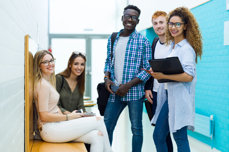 Portrait of group of happy young students looking at camera in a university.