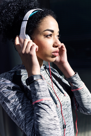 Portrait of fit and sporty young woman listening to music with mobile phone.の写真素材